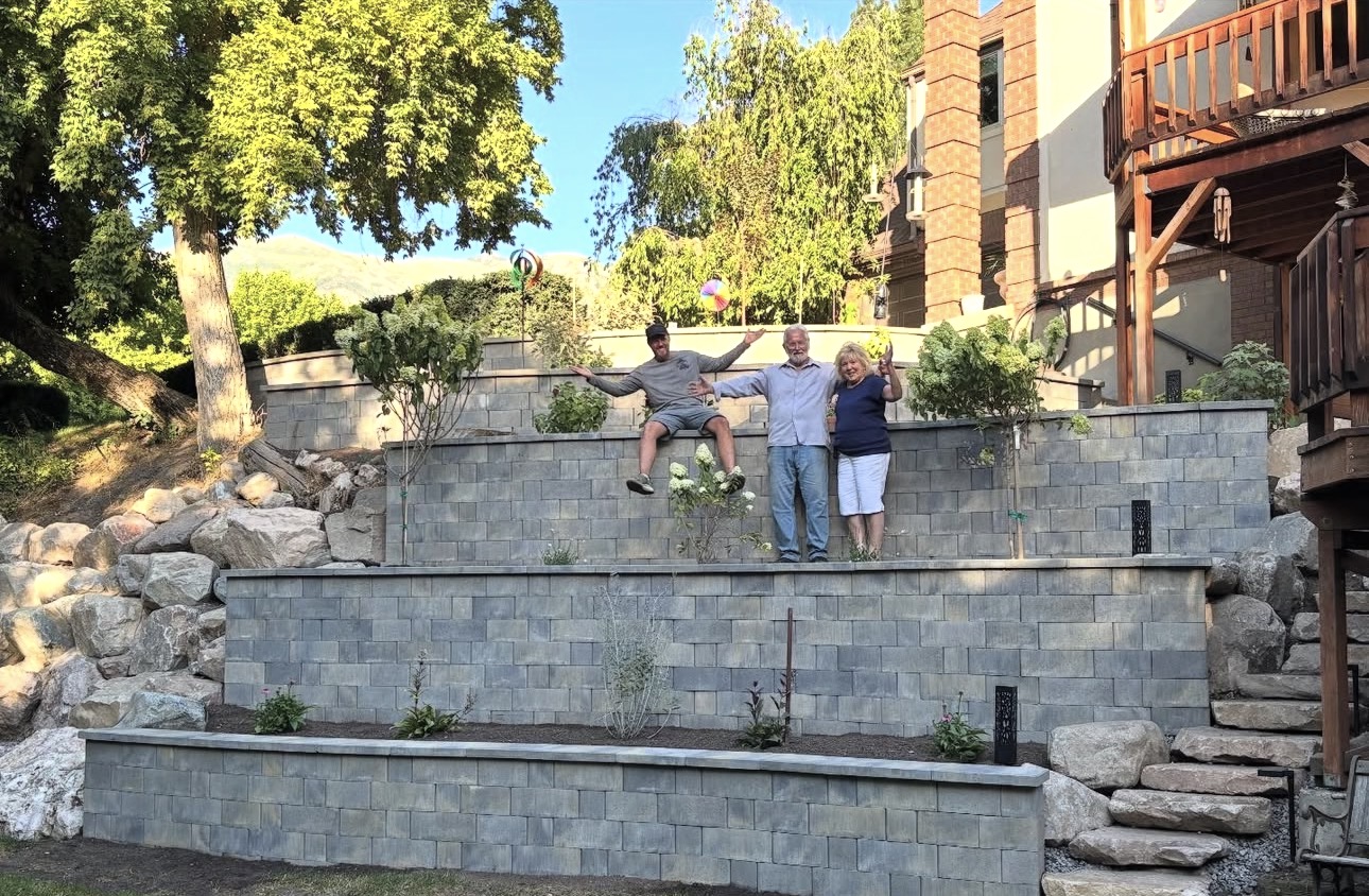 Finished multi tier segmental block retaining wall with planting and happy clients