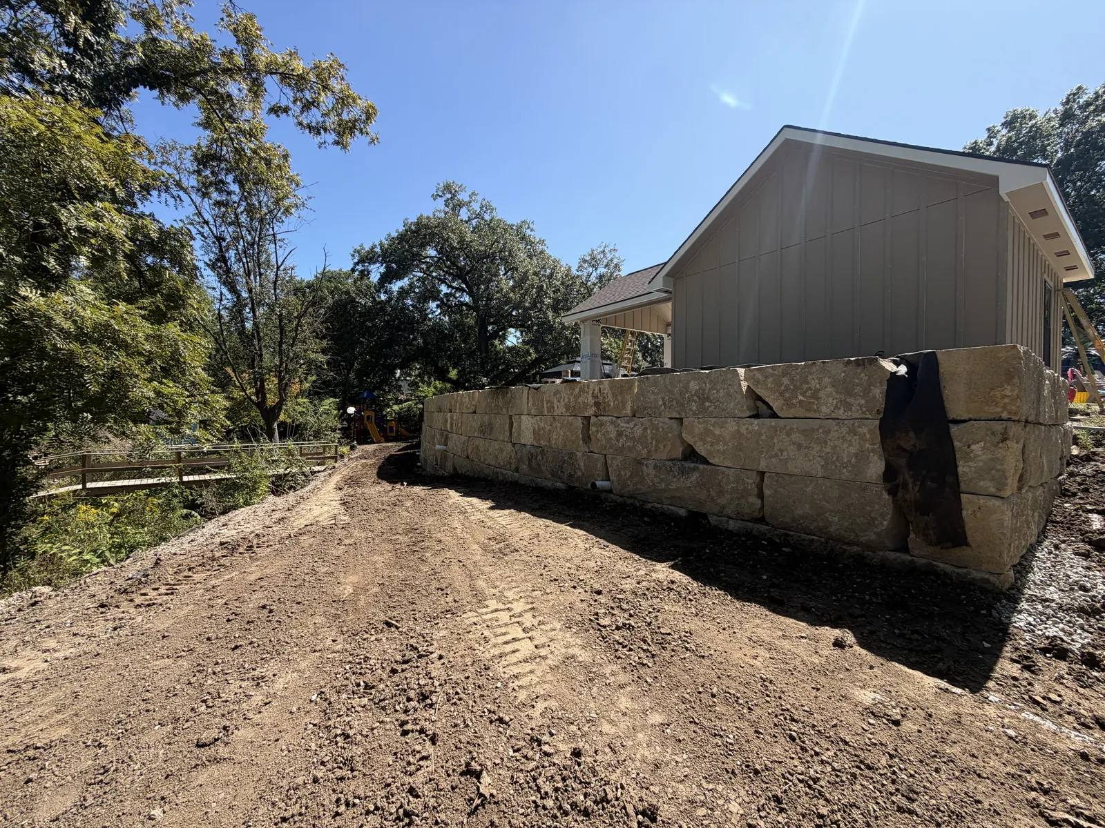 Limestone boulder wall along a graded yard